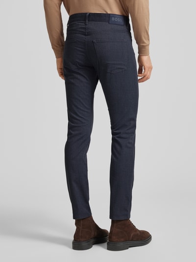 Männermodel trägt Slim Fit Stoffhose mit Baumwoll-Anteil Modell 'DELAWARE5' von BOSS, Optik: Allover-Muster, Passform: Slim Fit, Applikation: Label-Patch, Details: Gürtelschlaufen, Verschluss: Knopf und verdeckter Reißverschluss, 5-Pocket-Design, dunkle Farbe, glatte Textur, Ganzkörperansicht Rückansicht.