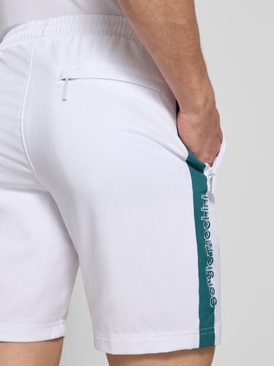 Männermodel trägt Shorts mit Logo-Print Modell 'GOCCIA' von SERGIO TACCHINI im weißen Material-Mix mit Stretch-Anteil, Detailaufnahme