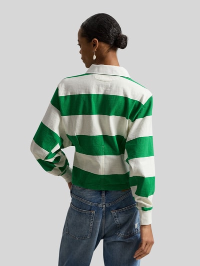 Männermodel trägt Regular Fit Poloshirt aus reiner Baumwolle von Polo Ralph Lauren, gestreift grün-weiß, Piqué, Logo, Ganzkörperansicht Rückansicht.