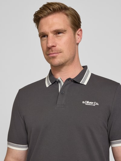 Männermodel trägt Regular Fit Poloshirt aus Baumwoll-Mix von s.Oliver RED LABEL, Optik: Unifarben, Label-Print, Nahaufnahme Oberkörper.