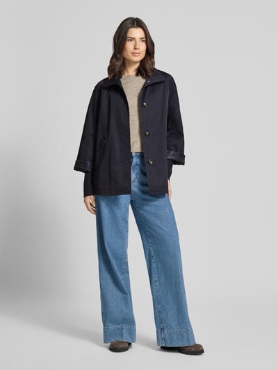 Modelka nosi Relaxed Fit Jacke mit Stehkragen od comma z mieszanki bawełny, wpuszczane kieszenie, elastyczne zakończenia rękawów, długość tyłu 70 cm, szerokość ramion 48 cm, szerokość w rozmiarze S 58 cm, długość rękawów 73 cm, kolor ciemny granat, gładka faktura, widok całego ciała z przodu.