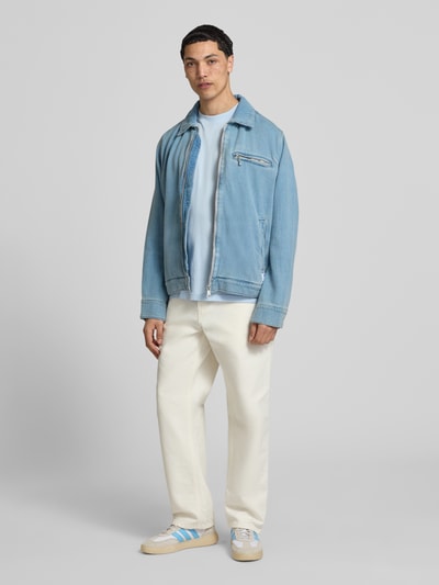 Męski model nosi Regular Fit Jeansjacke aus reiner Baumwolle Modell 'ELZO' od HUGO Blue, jasnoniebieski denim, zamek, kieszenie, webowana bawełna, całopostaciowy widok z przodu.