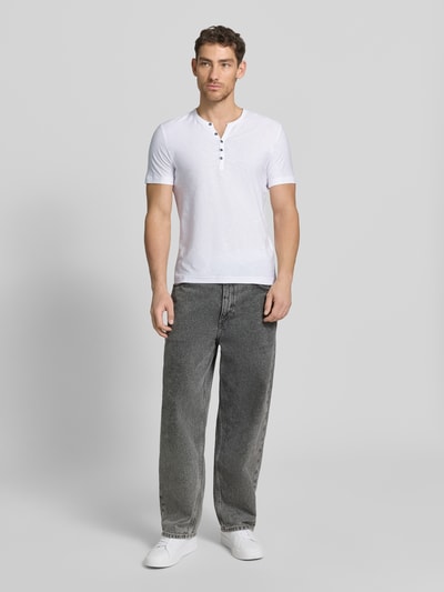 Männermodel trägt T-Shirt mit V-Ausschnitt und Knopfleiste von MCNEAL in Weiß, Regular Fit, reine Baumwolle, Ganzkörperansicht von vorne.