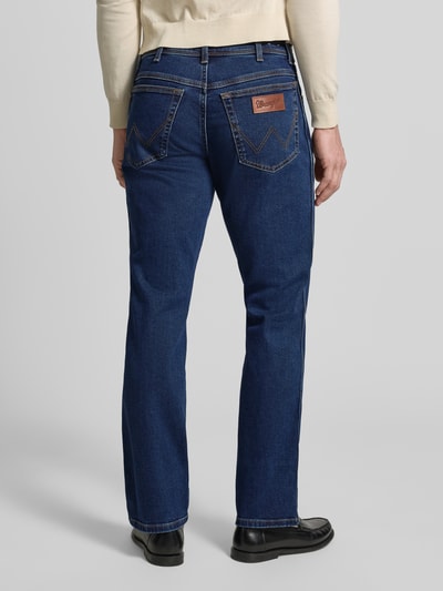 Männermodel trägt Straight Fit Jeans im 5-Pocket-Design Modell 'Texas' von Wrangler in Dunkelblau, Baumwoll-Mix, Ganzkörperansicht Rückansicht.