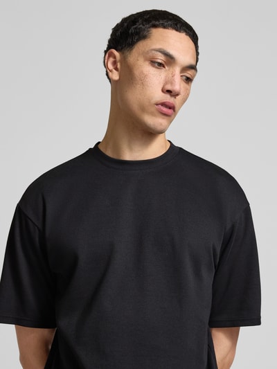 Männermodel trägt Boxy Fit T-Shirt aus Baumwoll-Mix Modell 'CASPIAN AIRFLEX BOXY' von Only & Sons, Optik: Unifarben, Nahaufnahme Oberkörper.