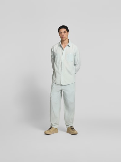 Männermodel trägt Freizeithemd mit Brusttasche von Kenzo in hellem Blau aus reiner Baumwolle, Relaxed Fit, Ganzkörperansicht von vorne
