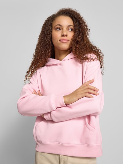 Frauenmodel trägt Relaxed Fit Hoodie mit Baumwoll-Anteil Modell 'ADELE' von ONLY in Optik: Unifarben, Sweat-Material-Mix, Kängurutasche, Kapuze, Langarm, gerippte Abschlüsse, Ganzkörperansicht von vorne.