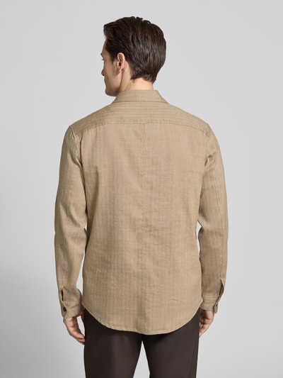 Männermodel trägt Regular Fit Hemdjacke mit Eingrifftaschen von Tiger Of Sweden aus reiner Baumwolle in Beige, Ganzkörperansicht Rückansicht. Rückenlänge bei Größe M: 76 cm, Kentkragen, Brusttaschen.