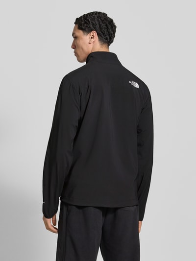 Männermodel trägt Jacke mit Stehkragen und Logo von The North Face, mieszanka materiałów z dodatkiem streczu, krój regular fit, stójka, zamek błyskawiczny, logo, kieszenie zapinane na zamek błyskawiczny, długość tyłu w rozmiarze M: 71 cm, szerokość ramion w rozmiarze M: 46 cm, szerokość w rozmiarze M: 56 cm, długość rękawów w rozmiarze M: 58 cm, czarny kolor, gładka tekstura, Ganzkörperansicht Rückansicht