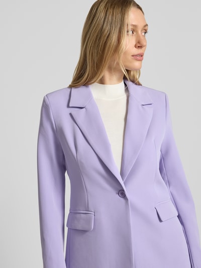 Frauenmodel trägt Slim Fit Blazer mit Pattentaschen Modell 'Isa' von GUIDO MARIA KRETSCHMER WOMAN aus Material-Mix mit Stretch-Anteil, Reverskragen, 1-Knopfverschluss, in zartem Flieder und glatter Struktur, Nahaufnahme Oberkörper.