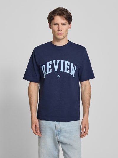 Mannenmodel draagt T-shirt met Label-Print en Rundhalsausschnitt van REVIEW, donkerblauw, puur katoen, regular fit, ruglengte maat M 69 cm, geheellichaamsaanzicht van voren.
