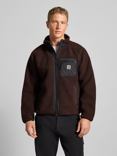 Männermodel trägt Fleecejacke mit Brusttasche Modell 'PRENTIS LINER' von Carhartt Work In Progress, braun, strukturierte Textur, Ganzkörperansicht von vorne.