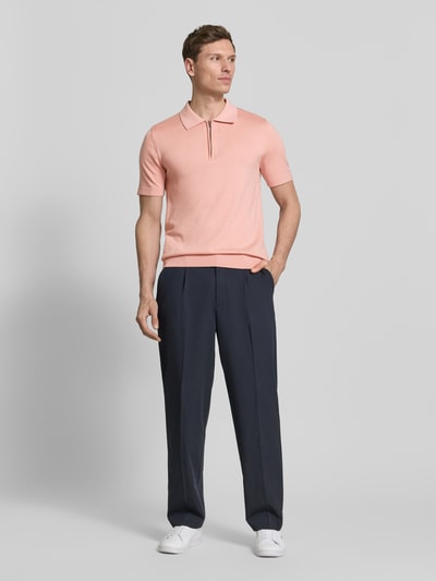 Männermodel trägt Regular Fit Poloshirt aus reiner Wolle Modell 'TRAY' von SELECTED HOMME in Rosa, unifarben, Strick, Ganzkörperansicht von vorne
