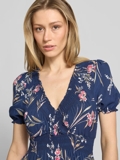Kobiece modelka ma na sobie Maxikleid aus Viskose mit V-Ausschnitt od Apricot, ciemnoniebieski kolor, kwiatowy wzór, dekolt V, elastyczny pasek w talii, czysta wiskoza, szerokość w rozmiarze S: 25 cm, długość pleców w rozmiarze S: 133 cm, długość rękawa w rozmiarze S: 22 cm, zbliżenie na górną część ciała
