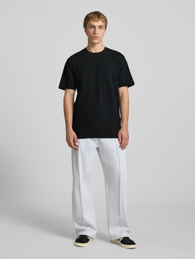 Männermodel trägt Regular Fit T-Shirt aus Baumwoll-Mix Modell 'KIAN' von Only & Sons, unifarben, Piqué-Struktur, Ganzkörperansicht von vorne