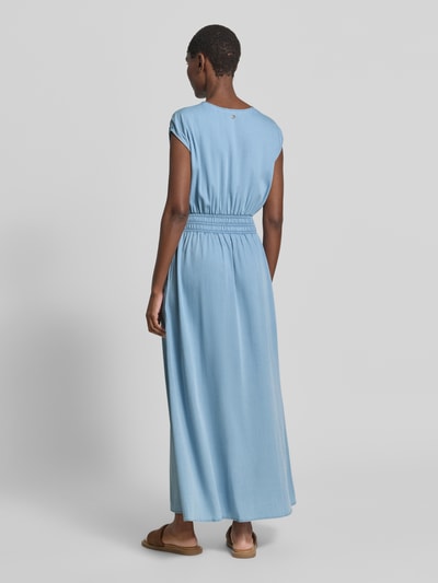 Frauenmodel trägt Maxikleid mit Kappärmeln und Smok-Details Modell 'Paola' von MOS MOSH, Lyocell-Mix mit Viskose-Anteil, taillierter Schnitt, hellblaue Farbgebung, weiche Textur, Rückenlänge 138 cm bei Größe S, Brustweite 39 cm, Ganzkörperansicht Rückansicht.