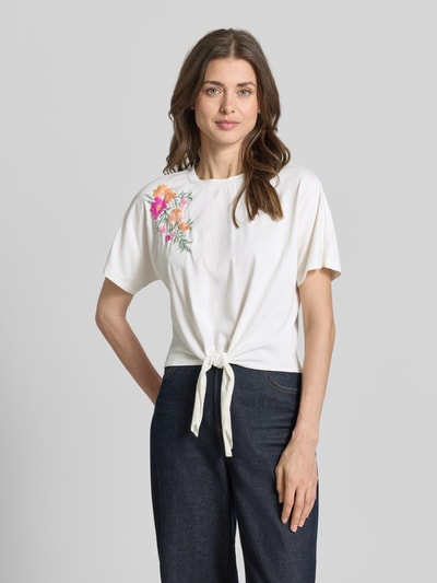 Frauenmodel trägt Regular Fit T-Shirt mit floralem Stitching Modell 'Fabian' von YAS in Weiß, Baumwolle, Zierknoten, Nahaufnahme Oberkörper.