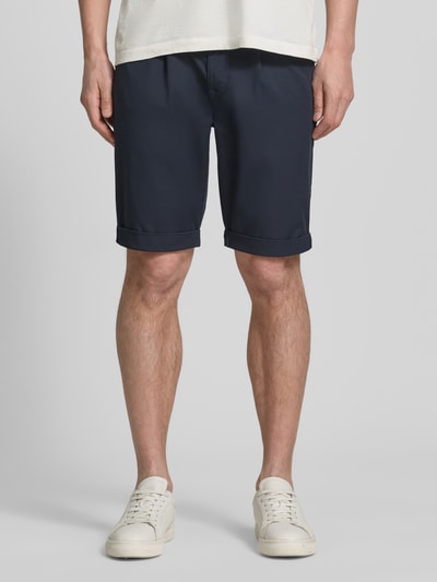 Männermodel trägt Chino-Shorts mit Gesäßleistentaschen von Lerros aus dunkelblauem Baumwoll-Mix mit Stretch-Anteil, Straight Fit, elastischer Bund mit Knopf- und Reißverschluss, französische Eingrifftaschen, Bundweite bei Größe 32: 42 cm, Innenbeinlänge bei Größe 32: 24 cm, glatte Textur, Ganzkörperansicht von vorne.
