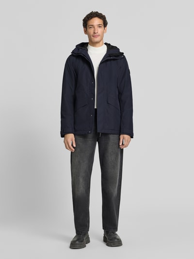 Männermodel trägt Regular Fit Jacke mit Kapuze Modell 'Adam' von Didriksons in Dunkelblau, Eingrifftaschen, Ganzkörperansicht von vorne. Rückenlänge 79 cm, Schulterbreite 46 cm, Brustweite 58 cm, Ärmellänge 73 cm.