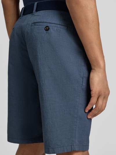 Männermodel trägt Bermudas mit Gürtel und Gesäßleistentaschen von Christian Berg Men aus Baumwoll-Mix mit Stretch-Anteil, Ganzkörperansicht Rückansicht.