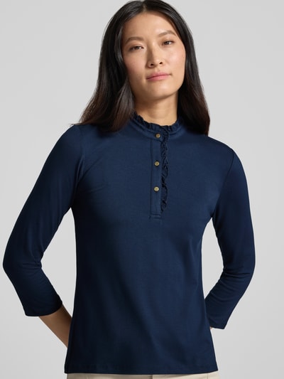 Frauenmodel trägt T-Shirt aus Viskose-Mix mit Rüschenbesatz von MORE & MORE in Dunkelblau, Stehkragen, 3/4-Arm, Nahaufnahme Oberkörper.