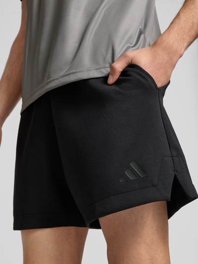 Männermodel trägt Regular Fit Sweatshorts mit Modal und Baumwoll-Anteil von adidas Sportswear, Optik: Unifarben, Logo-Detail, Materialverarbeitung: Sweat, Detailaufnahme Oberschenkel.