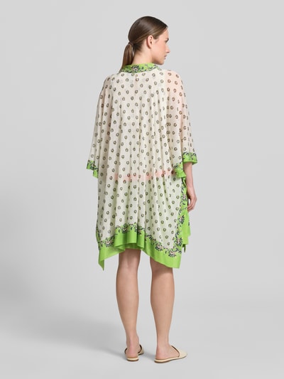 Frauenmodel trägt Cardigan mit offener Front und Kimonoärmeln von Marc Cain im Baumwoll-Mix, Loose-Fit, florale Muster, grün-creme, Ganzkörperansicht Rückansicht. Rückenlänge bei Größe 38: 84 cm, Ärmellänge bei Größe 38: 38 cm.