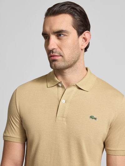 Männermodel trägt Slim Fit Poloshirt aus reiner Baumwolle von Lacoste, Optik: Unifarben, Logo-Stitching, Polokragen, Kurzarm, Materialverarbeitung: Piqué, Nahaufnahme Oberkörper.