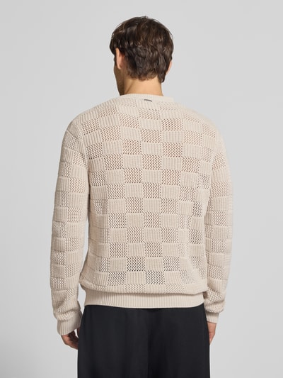Męski model nosi sweter z dzianiny Strickpullover mit Rundhalsausschnitt od Antony Morato, bawełna, krój regular fit, wzór na całej powierzchni, okrągły dekolt, długość tyłu w rozmiarze M: 73 cm, długość rękawów w rozmiarze M: 77 cm, widok całej sylwetki z tyłu.