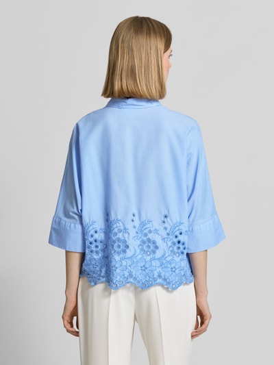 Frauenmodel trägt Boxy Fit Bluse mit Lochstickerei von Emily Van den Bergh in Hellblau, Reine Baumwolle, Hemdblusenkragen, Knopfleiste, Rückenlänge 54 cm, Ärmellänge 52 cm, Ganzkörperansicht Rückansicht.