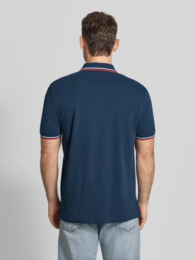 Männermodel trägt Regular Fit Poloshirt mit Kontraststreifen von Christian Berg Men aus Reine Baumwolle, Rückenlänge 71 cm, Ganzkörperansicht Rückansicht.