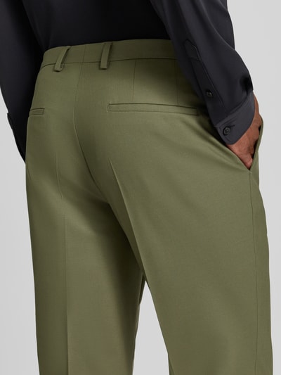 Männermodel trägt Super Slim Fit Anzughose aus Woll-Mix Modell 'Hesten253X' von HUGO in Olivgrün, feine Stoffstruktur, Nahaufnahme Rückansicht, Herren Anzughose von HUGO.