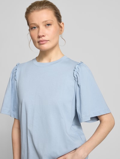 Modelka kobieca nosi Regular Fit T-Shirt aus reiner Baumwolle Modell 'PENELOPE' od Selected Femme, niebieski, jednolity, falbanki, okrągły dekolt, półrękaw, bawełna, zbliżenie górnej części ciała od przodu.