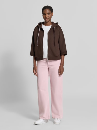 Vrouwenmodel draagt Oversized Sweatjacke met doppeltem Kordelzug van Smith and Soul in katoenmix, oversized fit, capuchon met dubbele tunnelkoord, tweewegritssluiting, Raglanmouwen, lichtroze broek, witte top, witte sneakers, effen kleuren, gladde texturen, Ganzkörperansicht van voren.