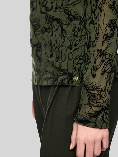 Vrouwenmodel draagt shirt met lange mouwen uit mesh van Marc Cain, Materiaalmix met viscose, getailleerd model, Col, detailopname zijkant. Ruglengte bij maat 36: 60 cm