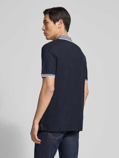 Męski model nosi Modern Fit Poloshirt mit Stitching od Fynch-Hatton, czarny kolor, czysta bawełna, krój modern fit, polokraga, zapięcie na guziki, stitching, długość pleców w rozmiarze M: 65 cm, widok całej sylwetki z tyłu.