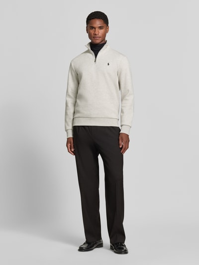Männermodel trägt Regular Fit Troyer aus Baumwoll-Mix von Polo Ralph Lauren in Hellgrau mit schwarzen Stoffhosen, Ganzkörperansicht von vorne. Herren Troyer von Polo Ralph Lauren.