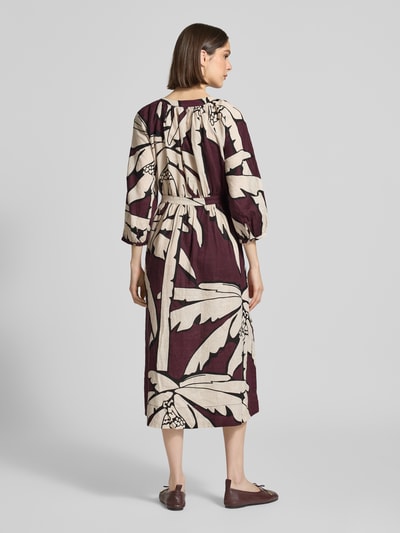 Frauenmodel trägt Midikleid aus reinen Leinen mit floralem Allover-Print von Christian Berg Woman, Creme-Bordeaux, Tailliert, 3/4-Arm, Knopfleiste, Ganzkörperansicht Rückansicht.