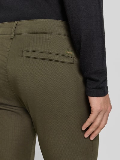 Mężczyzna nosi zielone chinosy Slim Fit Chino aus Baumwoll-Mix model 'Chino Slim 2' od BOSS Orange, detal tylnej części, zbliżenie