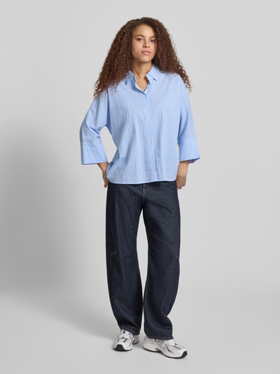 Frauenmodel trägt Boxy Fit Bluse aus reiner Baumwolle Modell 'AUGUSTA' von Only mit Optik: Allover-Muster, gestreift, Kimonoärmel, Hemdkragen, einreihige Knopfleiste, Twillgewebe, Ganzkörperansicht von vorne.