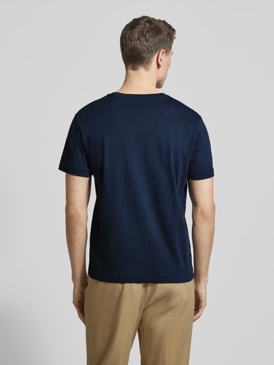 Männermodel trägt Regular Fit T-Shirt aus reiner Baumwolle von Tom Tailor, unifarben, Logo-Stitching, kurzarm, Ganzkörperansicht Rückansicht.