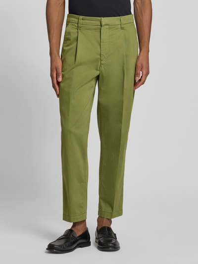 Männermodel trägt Regular Fit Chino aus Baumwoll-Mix Modell 'TAAMIR PLEATED' von Armedangels in Unifarben, Nahaufnahme Unterkörper.