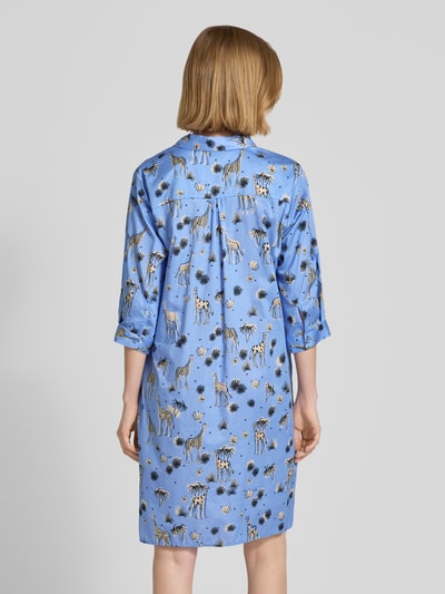Frauenmodel trägt Relaxed Fit Kleid mit Allover-Motiv-Print von Smith and Soul in Blau mit Tiermotiven aus reiner Baumwolle, Ganzkörperansicht Rückansicht.