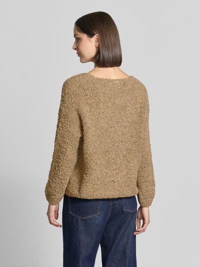 Frauenmodel trägt Relaxed Fit Strickjacke aus Woll-Viskose-Mix Modell 'Sofia' von ZABAIONE in Hellbraun, grobe Textur, Ganzkörperansicht Rückansicht, Damen Strickjacke, langer Arm, V-Ausschnitt, durchgehende Knopfleiste, Rückenlänge 62 cm, Ärmellänge 45 cm.