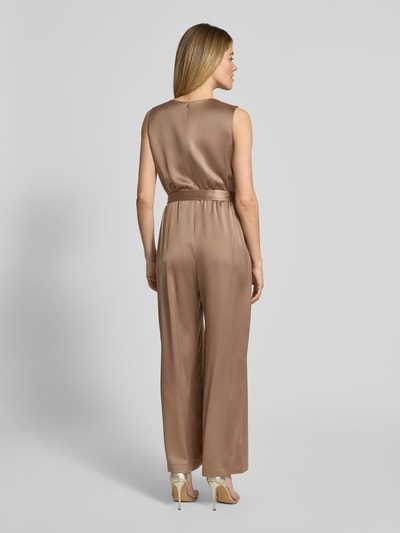 Frauenmodel trägt Shaped Fit Jumpsuit mit Taillengürtel zum Binden von s.Oliver BLACK LABEL in unifarbenem Satin, Ganzkörperansicht Rückansicht.