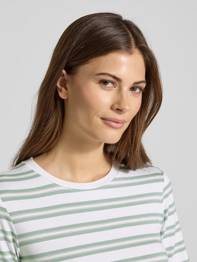 Frauenmodel trägt T-Shirt mit Rundhalsausschnitt von Comma, gestreiftes Design in Grün und Weiß, Viskose-Mix mit Stretch-Anteil, körpernaher Fit, Nahaufnahme Oberkörper.