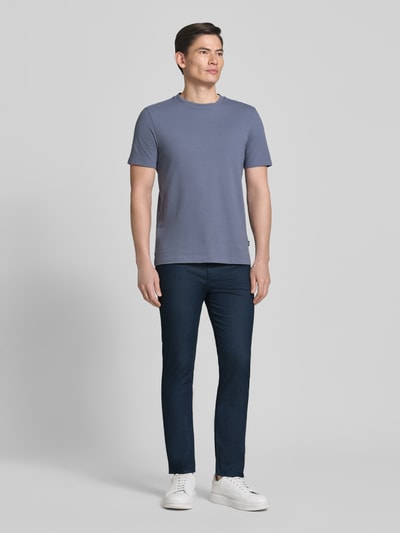Männermodel trägt Slim Fit Modell Chino aus Baumwoll-Mix 'DELAWARE5' von BOSS in Dunkelblau, unifarben, 5-Pocket-Design, Ganzkörperansicht von vorne.