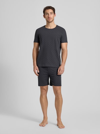 Männermodel trägt T-Shirt mit Logo-Muster und Rundhalsausschnitt von JOOP! Collection, Baumwoll-Elasthan-Mix, Regular-Fit, dunkle Farbe, Rückenlänge bei Größe M 68 cm, Ganzkörperansicht von vorne.