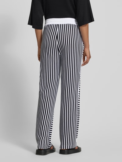 Frauenmodel trägt HOSE im Allover-Look mit elastischem Bund und Tunnelzug von Marc Cain, Schwarz-Weiß Strukturmuster, Reine Baumwolle, Relaxed-Fit, Ganzkörperansicht Rückansicht.