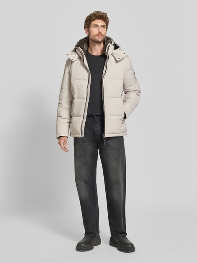 Männermodel trägt Regular Fit Steppjacke mit Reißverschlusstaschen Modell 'ARCOLA' von Strellson in Beige, Herren Steppjacke, Ganzkörperansicht von vorne.